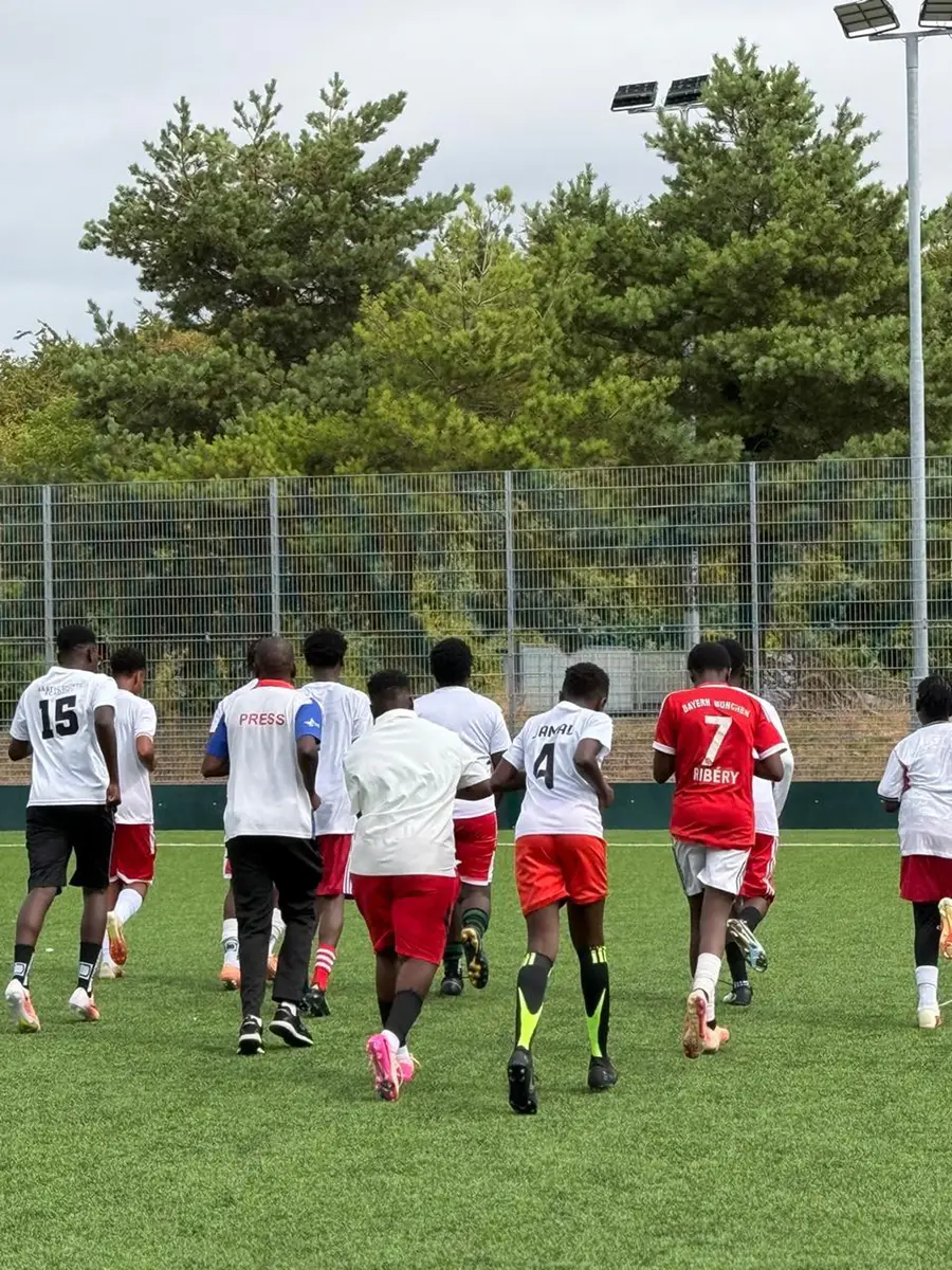 A youth football team warming up together on the pitch